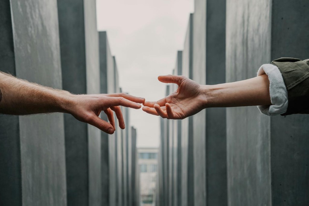 Two hands reaching toward each other — partnership and connection